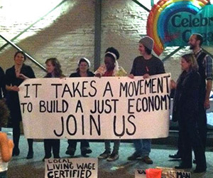 group of volunteers holding economic justice sign